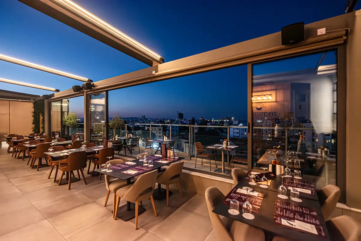 Panoramic rooftop dining area at Memories Rooftop Restaurant featuring city views and modern restaurant seating