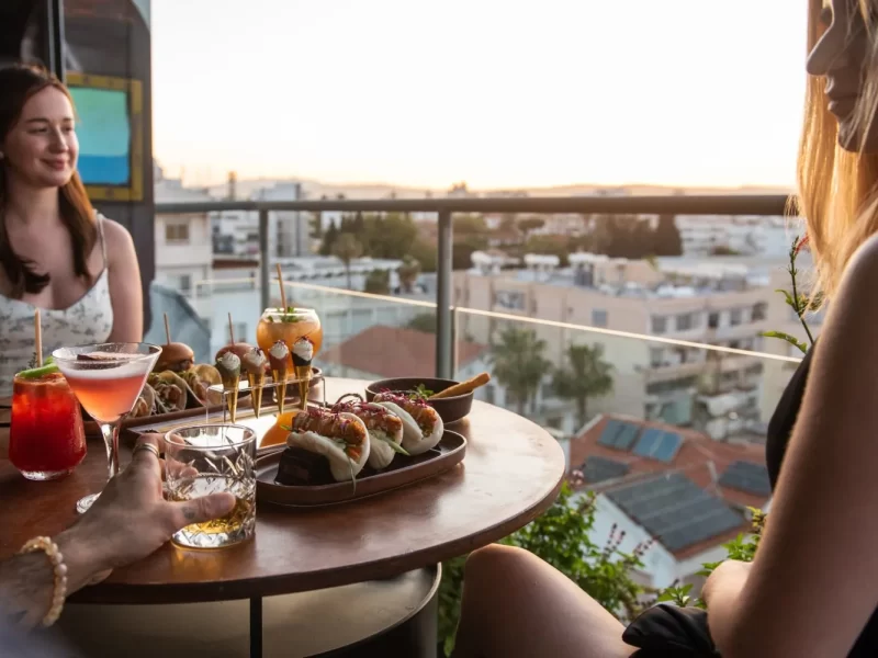 Two women enjoying drinks at a rooftop table