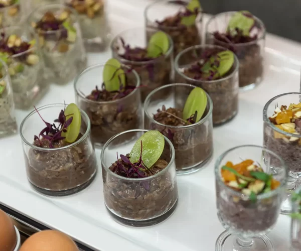 Glass cups filled with chocolate and chia seed pudding topped with fruits