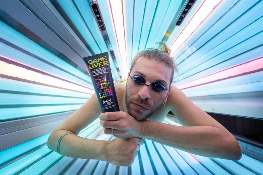 Man holding tanning product in a sunbed