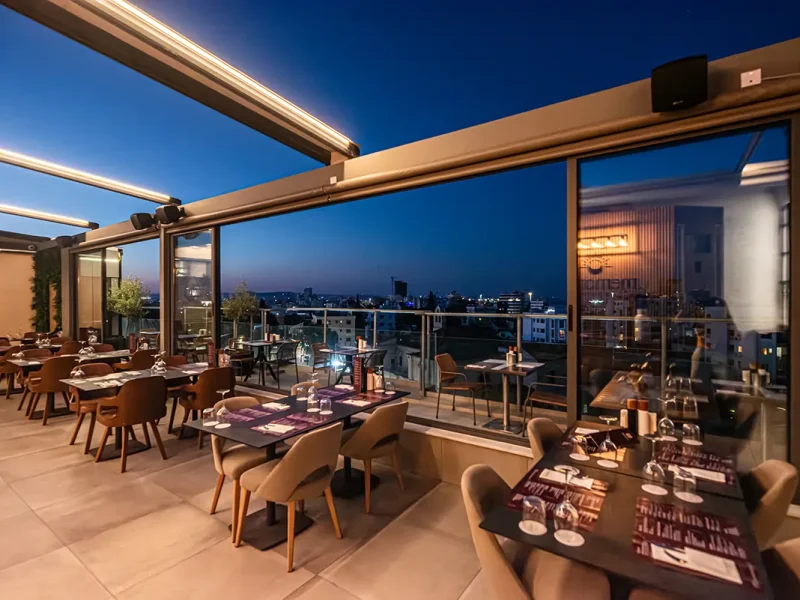 Panoramic rooftop dining area at Memories Rooftop Restaurant featuring city views and modern restaurant seating