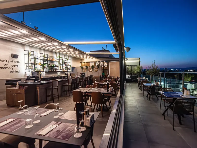 Memories Rooftop Bar and Restaurant at Rise Urban Art Hotel Larnaca with elegant dining tables, stylish seating, and panoramic city views